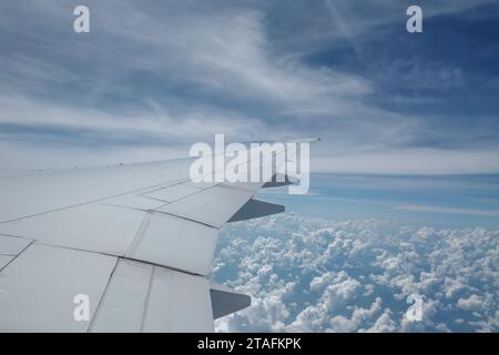 Beau ciel bleu profond clair sur une épaisse couche de nuages à l'atmosphère stratosphérique vue de la fenêtre de l'avion située au-dessus de l'aile de l'avion. Banque D'Images