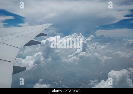 Beau ciel bleu profond clair sur une épaisse couche de nuages à l'atmosphère stratosphérique vue de la fenêtre de l'avion située au-dessus de l'aile de l'avion. Banque D'Images