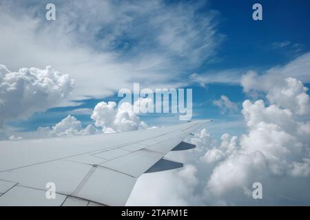 Beau ciel bleu profond clair sur une épaisse couche de nuages à l'atmosphère stratosphérique vue de la fenêtre de l'avion située au-dessus de l'aile de l'avion. Banque D'Images