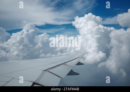 Beau ciel bleu profond clair sur une épaisse couche de nuages à l'atmosphère stratosphérique vue de la fenêtre de l'avion située au-dessus de l'aile de l'avion. Banque D'Images