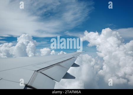 Beau ciel bleu profond clair sur une épaisse couche de nuages à l'atmosphère stratosphérique vue de la fenêtre de l'avion située au-dessus de l'aile de l'avion. Banque D'Images