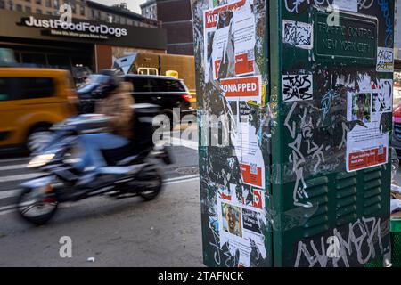 NEW YORK, NEW YORK - NOVEMBRE 30 : la circulation passe devant les restes d'images d'otages israéliens sur la partie ouest de Manhattan le 30 novembre 2023 à New York. Les affiches des otages pris en captivité par le Hamas lors de l'attaque terroriste contre Israël le 7 octobre ont été démaquillées dans toute la ville, puis souvent remplacées par de nouveaux tracts. Israël et le Hamas ont convenu de prolonger une trêve qui a duré près d’une semaine et qui promettait la libération d’un plus grand nombre d’otages israéliens détenus à Gaza, ainsi que la libération de prisonniers palestiniens détenus dans les prisons israéliennes. (Photo de Michael Nigro/Sipa USA) Banque D'Images