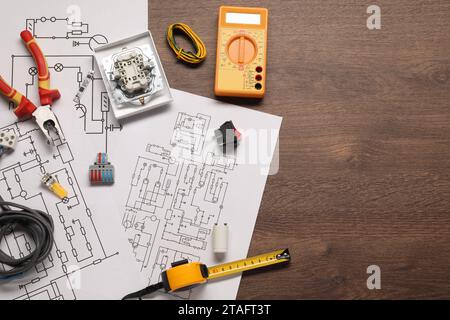 Composition de pose plate avec schémas de câblage et multimètre numérique sur table en bois, espace pour le texte Banque D'Images