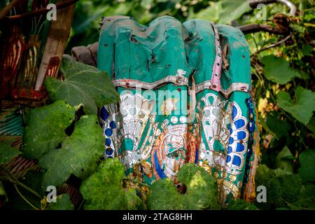 La canopée très décorée d'un taxi-pousse abandonné est vue à travers la végétation sur le bord de la route à Sylhet, au Bangladesh. Banque D'Images