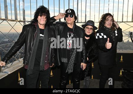 Tommy Thayer, Gene Simmons, Eric Singer, et Paul Stanley de KISS posent alors qu'ils éclairent l'Empire State Building pour célébrer le dernier concert du groupe Banque D'Images