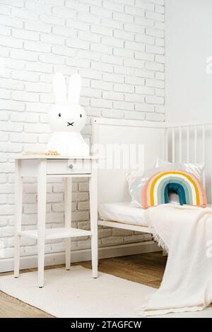 Intérieur de la chambre d'enfant avec lit confortable et oreiller arc-en-ciel Banque D'Images