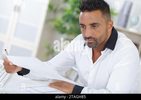 portrait d'un architecte regardant des plans au bureau Banque D'Images