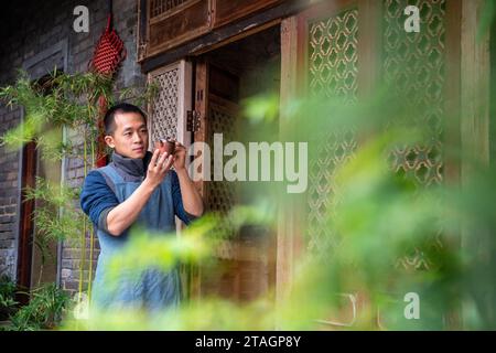 (231201) -- CHONGQING, 1 déc. 2023 (Xinhua) -- Guan Yongshuang vérifie une œuvre d'art en poterie dans son atelier du district de Rongchang à Chongqing, dans le sud-ouest de la Chine, le 14 novembre 2023. Liang Xiancai, 73 ans, est un héritier de l'artisanat de poterie de Rongchang, un patrimoine culturel immatériel en Chine. Malgré la tendance à la mécanisation, à l'automatisation et à la production de poterie à grande échelle, il maintient fermement la tradition de la poterie manuelle. Guan Yongshuang, 32 ans, est diplômé de l'Institut des Beaux-Arts du Sichuan avec une majeure en art potier Il étudie la culture de la poterie depuis près de dix ans. Guan Banque D'Images