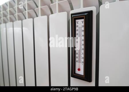 Thermostat de radiateur de chauffage réglé à basse température et thermomètre de pièce pour économiser de l'argent à des coûts de chauffage. Crise énergétique, efficacité énergétique et augmentation Banque D'Images