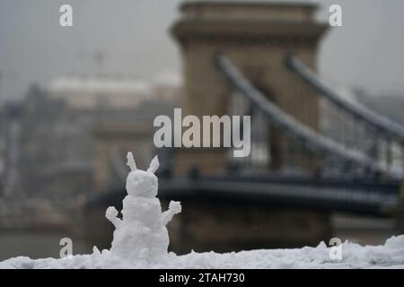 Budapest, Hongrie - 30 novembre 2023 : bonhomme de neige avec le pont de la chaîne sur le fond. Banque D'Images