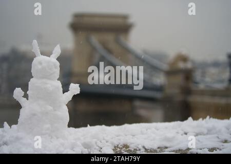 Budapest, Hongrie - 30 novembre 2023 : bonhomme de neige avec le pont de la chaîne sur le fond. Banque D'Images