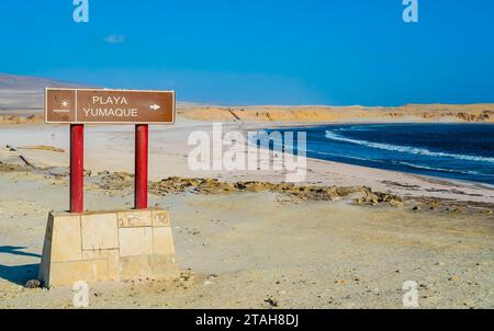 Vue panoramique de la plage de Yumaque avec enseigne touristique au premier plan, réserve nationale de Paracas, Pérou Banque D'Images