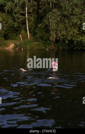 Nageur professionnel en combinaison nage en eau libre sur un lac. Banque D'Images