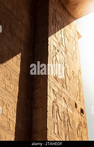 rayon de soleil doré atteignant les murs recouverts de hiéroglyphes égyptiens Banque D'Images