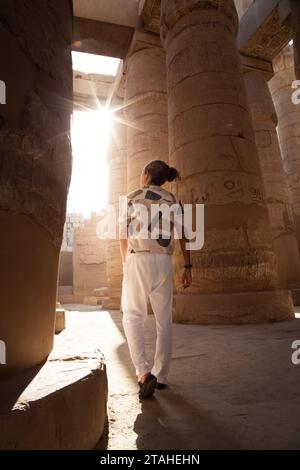 Homme avec hairbun, marchant autour de la salle hypostyle, temple Karnak Banque D'Images