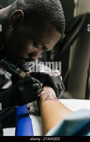 gros plan de tatoueur tatouant avec l'aiguille Banque D'Images