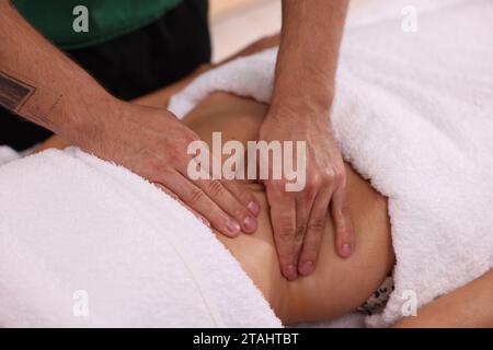 Femme recevant un massage professionnel du ventre à l'intérieur, closeup Banque D'Images