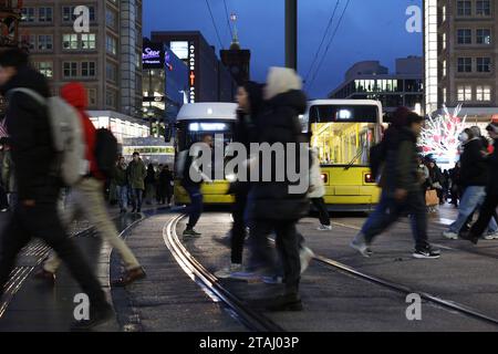 Berlin - Deutschland. Alexanderplatz, Leute Hasten über die Gleise, während eine Tram kommt. *** 24 11 2023, Berlin, Allemagne. 24 novembre 2023. Alexanderplatz, les gens se dépêchent sur les pistes pendant qu'un tramway arrive Credit : Imago/Alamy Live News Banque D'Images