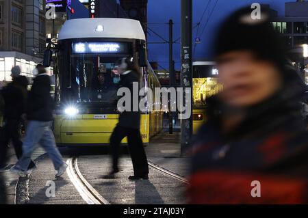 Berlin - Deutschland. Alexanderplatz, Leute Hasten über die Gleise, während eine Tram kommt. *** 24 11 2023, Berlin, Allemagne. 24 novembre 2023. Alexanderplatz, les gens se dépêchent sur les pistes pendant qu'un tramway arrive Credit : Imago/Alamy Live News Banque D'Images