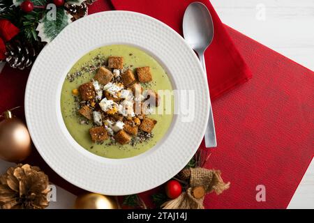 Crème d'artichaut avec croûtons de pain. Tapas végétaliennes espagnoles typiques.. Repas de Noël servis sur une table décorée de motifs de Noël. Banque D'Images