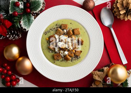 Crème d'artichaut avec croûtons de pain. Tapas végétaliennes espagnoles typiques.. Repas de Noël servis sur une table décorée de motifs de Noël. Banque D'Images