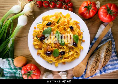 Rubans de pâtes avec citrouille sautée et olives noires. Banque D'Images