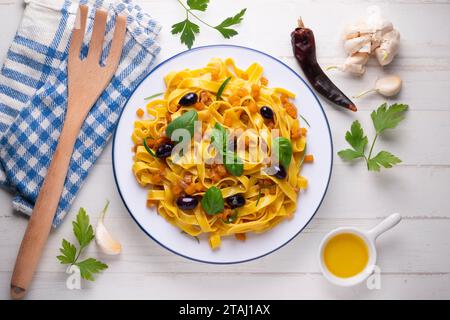 Rubans de pâtes avec citrouille sautée et olives noires. Banque D'Images