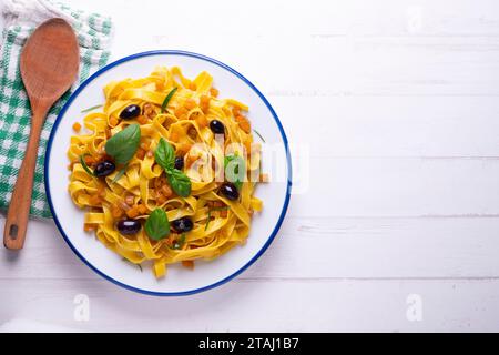 Rubans de pâtes avec citrouille sautée et olives noires. Banque D'Images