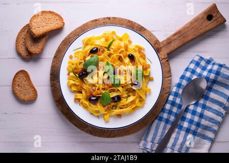 Rubans de pâtes avec citrouille sautée et olives noires. Banque D'Images