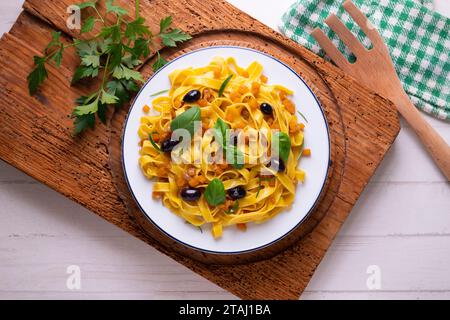 Rubans de pâtes avec citrouille sautée et olives noires. Banque D'Images