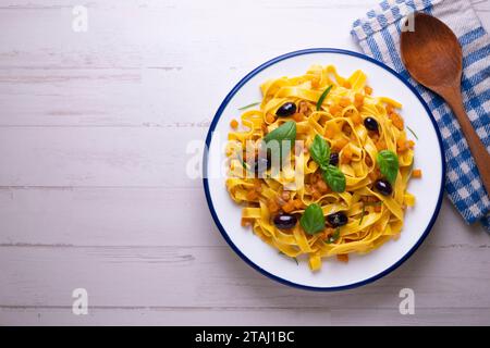 Rubans de pâtes avec citrouille sautée et olives noires. Banque D'Images