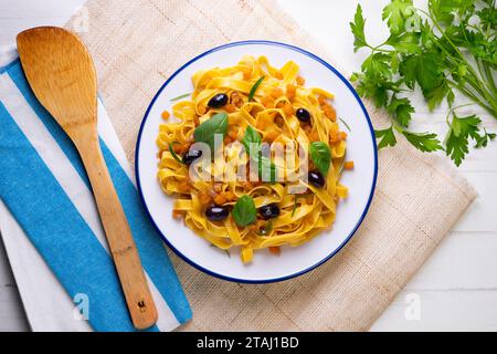 Rubans de pâtes avec citrouille sautée et olives noires. Banque D'Images