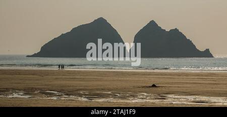 Les gens marchent sur la plage de Holywell Bay en face de gros rochers, Cornouailles, Angleterre Banque D'Images