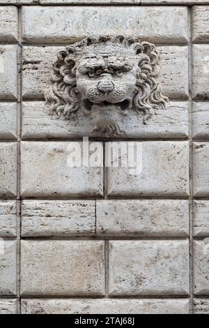 Une tête de lion décorative est montée sur un mur de pierre dans le village italien de Montepulciano, Toscane, Italie. Banque D'Images