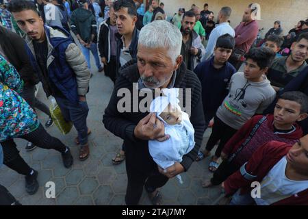 Le cadavre d'un bébé palestinien de 5 mois nommé Muhammad Hani Al-Zahar, est amené à l'hôpital des martyrs d'Al-Aqsa le cadavre d'un bébé palestinien de 5 mois nommé Muhammad Hani Al-Zahar, est amené à l’hôpital des martyrs d’Al-Aqsa par sa mère Asmahan Attia Al-Zahar et son grand-père Attia Abu Amra après les frappes aériennes israéliennes à la fin de la pause humanitaire à Deir Al-Balah, Gaza, le 1 décembre 2023. 32 Palestiniens ont été tués dans les 3 heures qui ont suivi la fin de la pause humanitaire à Gaza. Photo de Omar Ashtawy apaimages Dair El-Balah bande de Gaza territoire palestinien 011223 Dair Balah os Banque D'Images