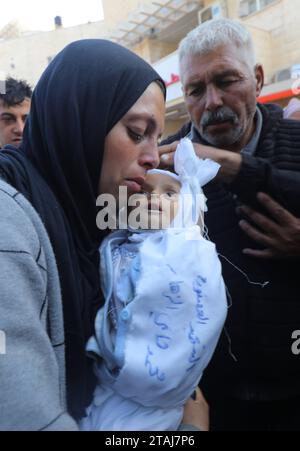 Le cadavre d'un bébé palestinien de 5 mois nommé Muhammad Hani Al-Zahar, est amené à l'hôpital des martyrs d'Al-Aqsa le cadavre d'un bébé palestinien de 5 mois nommé Muhammad Hani Al-Zahar, est amené à l’hôpital des martyrs d’Al-Aqsa par sa mère Asmahan Attia Al-Zahar et son grand-père Attia Abu Amra après les frappes aériennes israéliennes à la fin de la pause humanitaire à Deir Al-Balah, Gaza, le 1 décembre 2023. 32 Palestiniens ont été tués dans les 3 heures qui ont suivi la fin de la pause humanitaire à Gaza. Photo de Omar Ashtawy apaimages Dair El-Balah bande de Gaza territoire palestinien 011223 Dair Balah os Banque D'Images