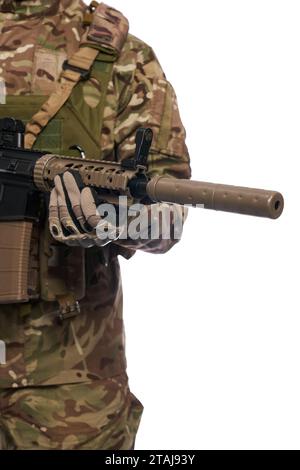 Homme de l'armée anonyme dans des gants tactiques tenant un fusil d'assaut sur la poitrine à l'intérieur. Vue rapprochée du canon de mitrailleuse d'arme à feu ngsw, tenu par un soldat militaire, isolé sur blanc. Arme, concept d'armée. Banque D'Images