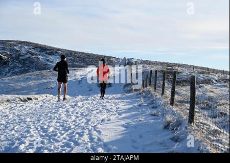 Édimbourg, Écosse, Royaume-Uni. 1 décembre 2023. La neige arrive dans le parc régional de Pentland. Jogging dans la neige. Crédit : Craig Brown/Alamy Live News Banque D'Images