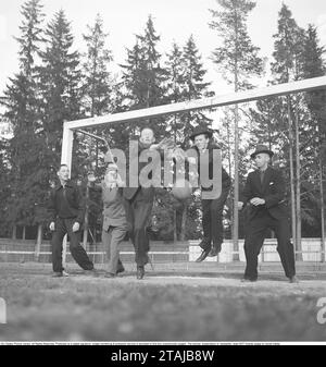 Le football dans les années 1940 Un groupe d'hommes, tous vêtus de costumes et de chapeaux dans un but de football. Quelqu'un essaie de marquer et ils plongent pour attraper la balle comme il vient. Suède 1943. Kristoffersson réf. D42-2 Banque D'Images