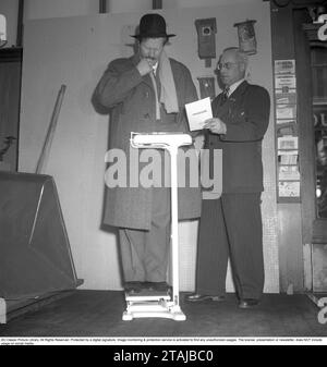 Sur la balance dans les années 1940 L'acteur Åke Fridell a l'air réfléchi lorsqu'il se tient debout sur la balance, peut-être que son poids n'est pas ce qu'il pensait qu'il serait. Suède 1949. Photo Kristoffersson réf. AN83-1 Banque D'Images