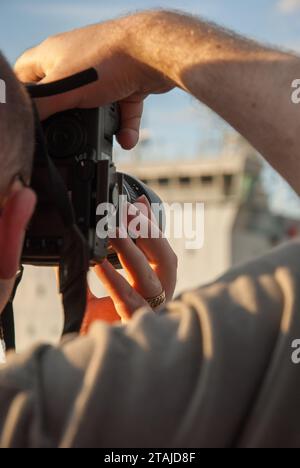 photographe au point prenant une photo, vue de dessus l'épaule Banque D'Images