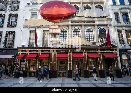 Londres, Royaume-Uni. 1 décembre 2023. Les gens passent devant l'extérieur du magasin de luxe Cartier sur Bond Street qui a été décoré pour Noël. Les détaillants espèrent une augmentation des ventes pendant la période des fêtes, alors que la crise du coût de la vie se poursuit. Crédit : Stephen Chung / Alamy Live News Banque D'Images