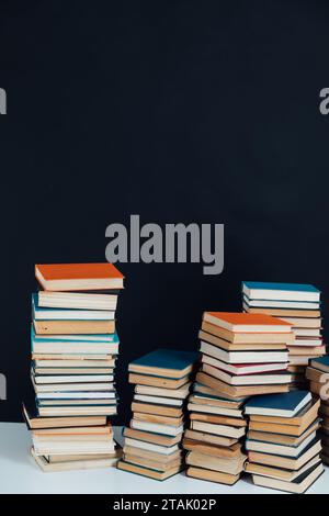 Beaucoup de piles de vieux livres éducatifs sur fond noir bibliothèque Banque D'Images