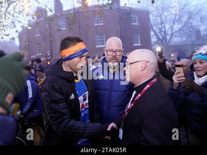 Kevin Sinfield accueille le révérend Canon Timothy Goode après avoir terminé la première journée de 7 en 7 dans 7 Challenge at York Minster. L'ancien capitaine de Leeds Rhinos est prêt à terminer sept autres ultra-marathons en autant de jours pour sensibiliser et mobiliser de l'argent pour soutenir les personnes touchées par la maladie neuronale motrice. Date de la photo : Vendredi 1 décembre 2023. Banque D'Images