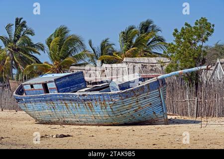 Vieux bateau de pêche en bois bleu sur la plage de sable au village côtier Belo sur Mer, district de Morondava, région de Menabe, Madagascar Banque D'Images