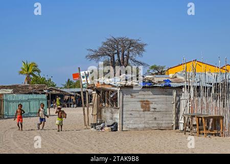 Streetscene montrant des cabanes / maisons en bois et des enfants jouant dans le village côtier Belo sur Mer, district de Morondava, région de Menabe, Madagascar Banque D'Images