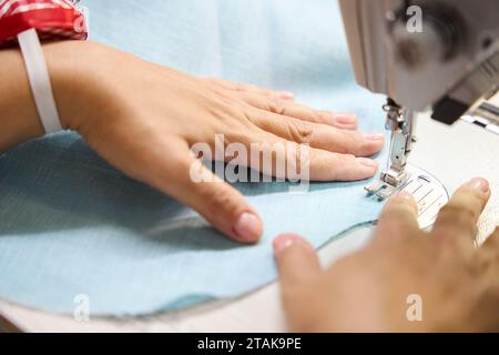 Femme coud une robe sur une machine à coudre Banque D'Images