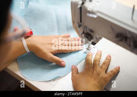 Couturière coud une robe sur une machine à coudre Banque D'Images