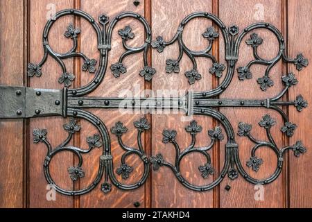 Richement orné, charnière en fonte d'une vieille porte en bois. Banque D'Images