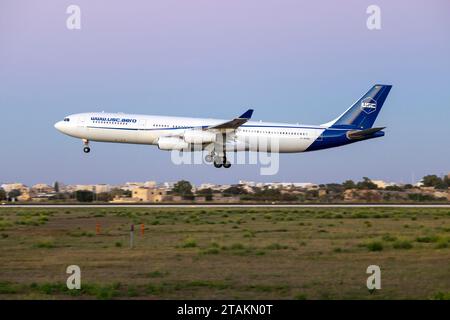 Universal Sky Carrier (USC) Airbus A340-313 (REG : D-AUSC) atterrissant avant l'obscurité totale. Banque D'Images